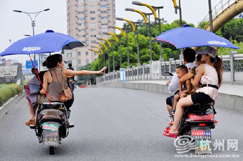 違規(guī)加裝遮陽傘的電動車，易翻車還危及行人安全（資料圖）